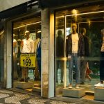 Interior de uma loja de moda masculina em São Paulo, com manequins e roupas expostas na vitrine.