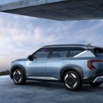 SUV elétrico estacionado em uma área residencial moderna, com paisagem ao fundo